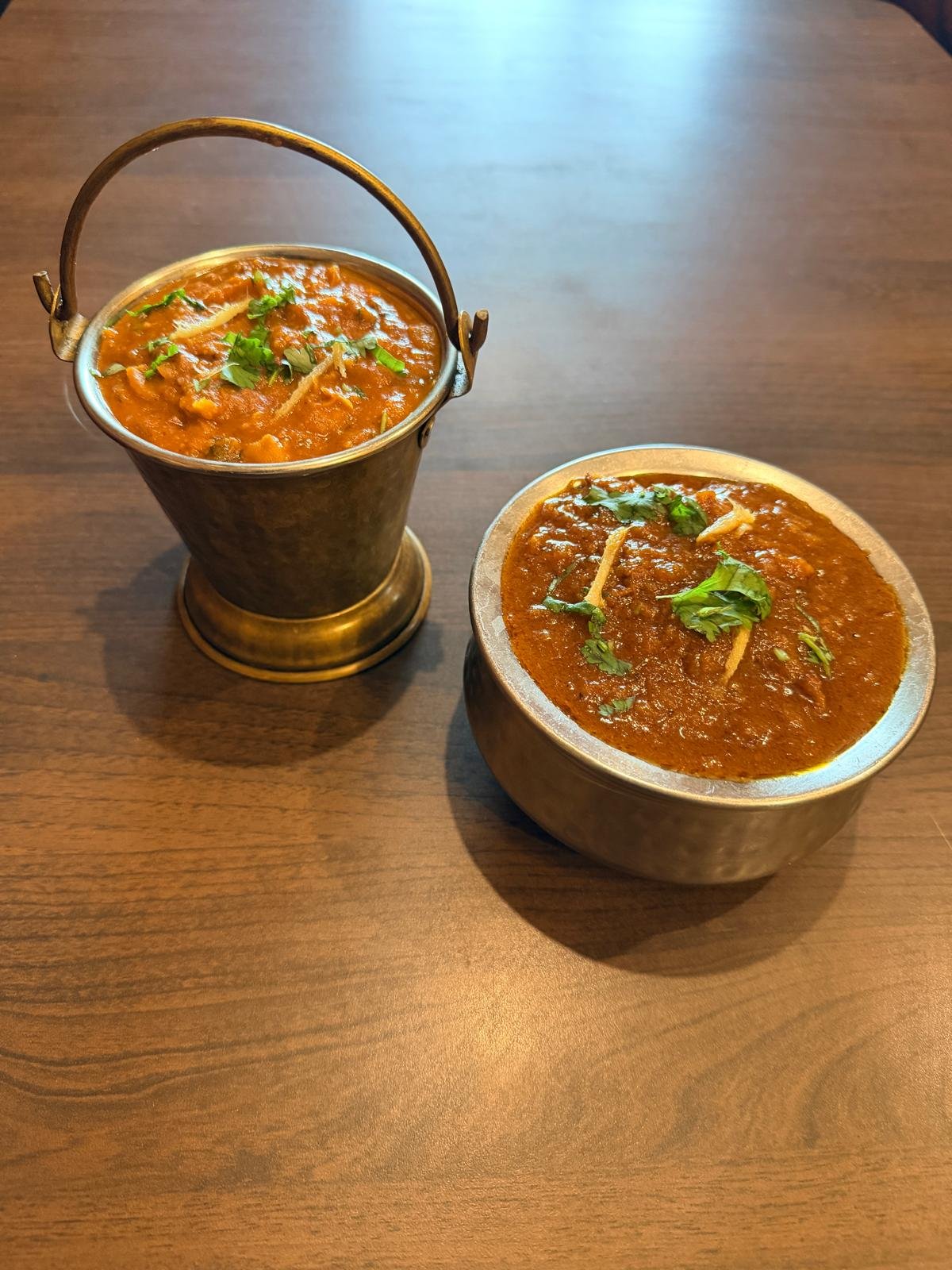 Indian curry served in a metal bowl at Morpeth Woodfire Pizza