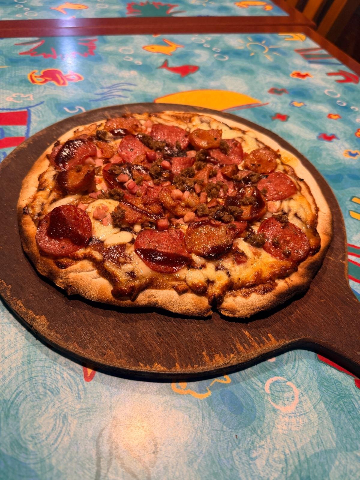 Woodfired pizza with sliced sausage and toppings at Morpeth Woodfire Pizza